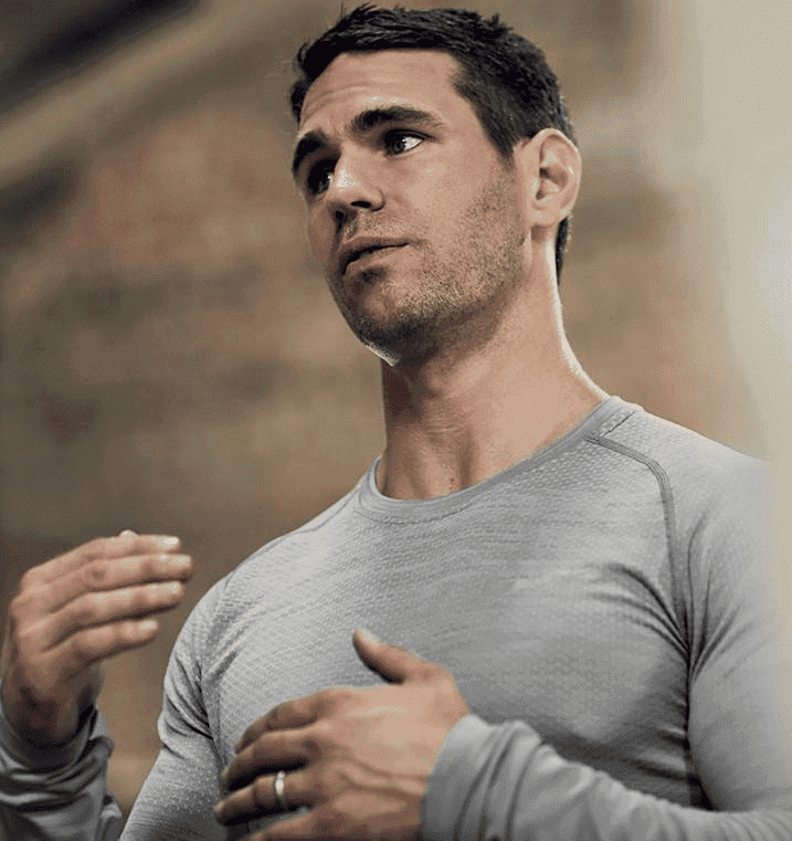 Man in gray shirt exercising, focused expression